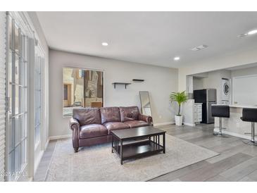 Cozy living room featuring a comfortable leather sofa, stylish coffee table, and a light-filled window at 4901 S Calle Los Cerros Dr # 119, Tempe, AZ 85282