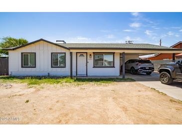 Charming single-story home with a carport, featuring a clean white facade and freshly painted trim at 6501 W Columbus Ave, Phoenix, AZ 85033