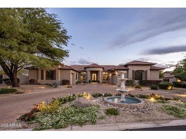 Stunning home featuring a circular driveway with water fountain and professional landscaping at 7327 E La Junta Rd, Scottsdale, AZ 85255