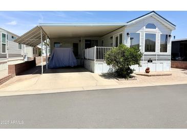 Charming mobile home showcasing ample covered parking and a well-maintained front yard at 7750 E Broadway Rd # 774, Mesa, AZ 85208