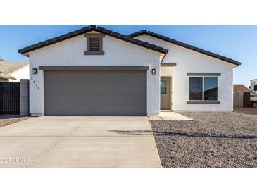 Charming single-story home featuring gray 2-car garage, gravel landscaping, and modern design at 8679 W Raven Dr, Arizona City, AZ 85123