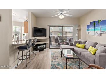 Relax in this charming living room with comfortable seating and access to the outdoor patio at 14950 W Mountain View Blvd # 1112, Surprise, AZ 85374