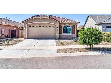 Charming single-story home featuring a well-manicured yard and a two-car garage at 16593 W Alameda Rd, Surprise, AZ 85387
