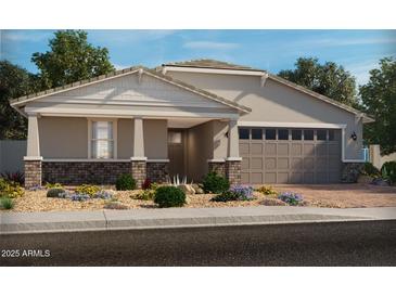 Charming single-story home with brick accents, a two-car garage, and desert landscaping at 17677 W Odeum Ln, Goodyear, AZ 85338