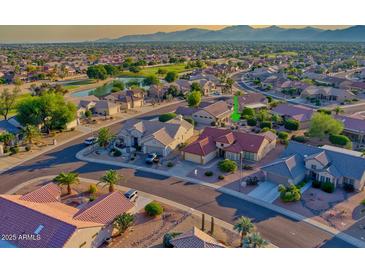 Stunning aerial view of homes in a golf course community with mountain views in the distance at 19472 N Marble Canyon Ct, Surprise, AZ 85374