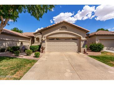 Charming single-Gathering home featuring a beige exterior, desert landscaping and a two-car garage at 23813 S Pleasant Way, Sun Lakes, AZ 85248