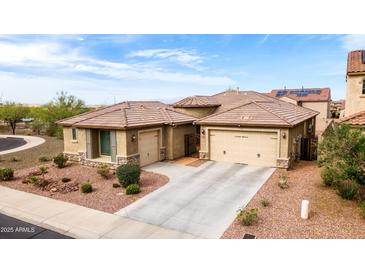Stunning home with a two-car garage, beautiful landscape, and a well-manicured lawn under a sunny blue sky at 25540 N 103Rd Dr, Peoria, AZ 85383