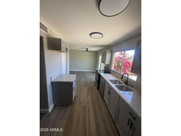 Bright kitchen features stainless steel appliances, granite countertops, and views to the spacious living area at 5723 N 44Th Ln, Glendale, AZ 85301