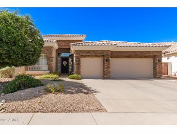 Charming single-story home featuring a neutral color scheme, landscaped front yard, and a two-car garage at 621 W Desert Ave, Gilbert, AZ 85233