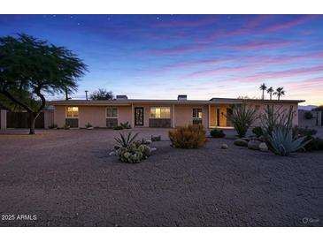 Charming single-story home featuring desert landscaping, cozy curb appeal, and ample natural light at dusk at 6602 E Heather Dr, Mesa, AZ 85215