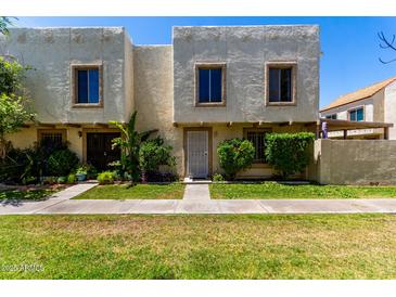 Charming two-story townhouse with lush landscaping and a well-manicured lawn at 7915 E Keim Dr, Scottsdale, AZ 85250