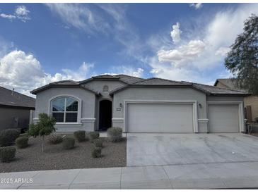 Charming single-story home with a three car garage, desert landscaping, and a neutral color palette at 10736 W Swayback Pass, Peoria, AZ 85383