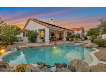 Enjoy this stunning backyard with pool, beautiful landscaping, and covered patio at 10907 E Bella Vista Dr, Scottsdale, AZ 85259