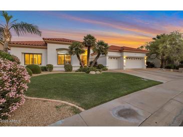 Charming single-story home boasting a well-manicured lawn, a three-car garage, and a tile roof at 10907 E Bella Vista Dr, Scottsdale, AZ 85259
