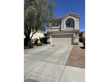 Charming two-story home featuring a two-car garage and well-maintained front yard landscaping at 11460 W Eden Mckenzie Dr, Surprise, AZ 85378