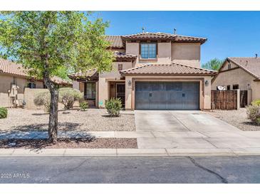 Two-story home featuring a tile roof, large driveway, and low maintenance desert landscaping at 14200 W Larkspur Dr, Surprise, AZ 85379