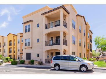 Charming, multi-level condo featuring private balconies, and desert landscaping with a silver van parked out front at 14575 W Mountain View Blvd # 11220, Surprise, AZ 85374