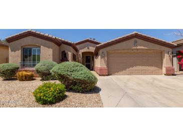Charming home exterior features desert landscaping, a two-car garage, and neutral color palette at 18072 W Paradise Ln, Surprise, AZ 85388