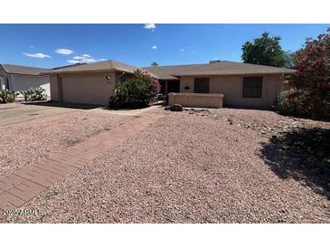 Charming single story home with desert landscaping, neutral color palette, and brick walkway leading to entrance at 2022 Leisure World --, Mesa, AZ 85206