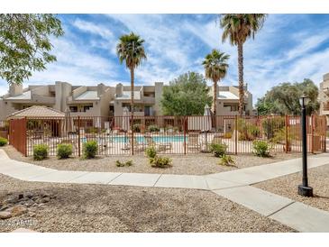 Relaxing community pool area surrounded by palm trees and well-maintained landscaping at 4850 E Desert Cove Ave # 240, Scottsdale, AZ 85254