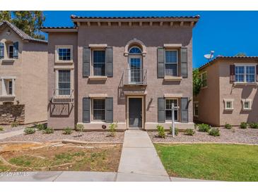 Charming home featuring symmetrical facade with dark shutters and a small balcony above the entry door at 5628 S 21St Pl, Phoenix, AZ 85040