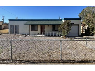 Charming single-story home with a fenced front yard, green roof and a one car garage at 7139 E Arcadia Cir, Mesa, AZ 85208