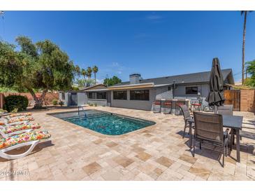 Spacious backyard featuring a refreshing in-ground swimming pool and inviting lounge chairs at 7727 E 4Th St, Scottsdale, AZ 85251
