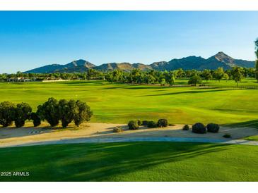 Expansive golf course with lush green fairways surrounded by mature trees and mountain views on a sunny day at 8312 N Golf Dr, Paradise Valley, AZ 85253