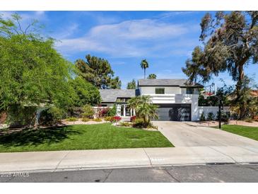 Beautiful home featuring a well-manicured lawn, a basketball hoop, and a modern two-story design at 10360 N 98Th St, Scottsdale, AZ 85258