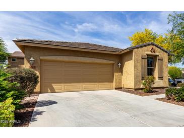 Exterior shot showcasing the two-car garage, neutral colors, and manicured landscaping against a blue sky at 1202 E Binner Dr, Chandler, AZ 85225