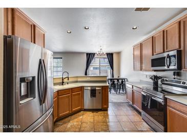 Spacious kitchen with stainless steel appliances, tile floors, and an eat-in dining area at 1265 S Aaron -- # 277, Mesa, AZ 85209