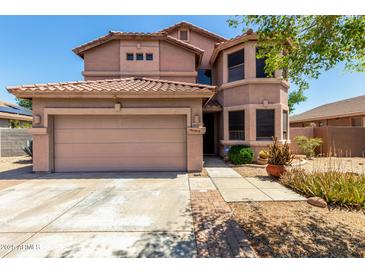 Two-story home with a neutral color scheme, well-maintained landscaping, and a two-car garage at 16527 N 71St Dr, Peoria, AZ 85382