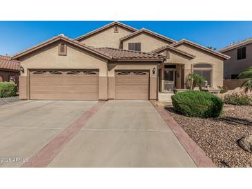 Charming single-story home features a tile roof and a spacious three-car garage at 26249 N 68Th Ln, Peoria, AZ 85383