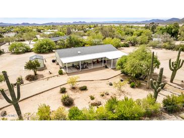 Aerial view of home showcasing covered patio, mature landscaping, and desert setting at 33852 N 52Nd St, Cave Creek, AZ 85331