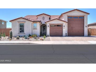 Charming single-story home with desert landscaping, tile roof and a three-car garage at 40725 W Hall Dr, Maricopa, AZ 85138