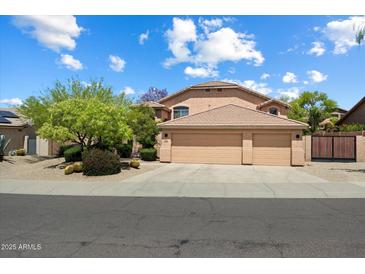 Inviting home featuring a three-car garage, desert landscaping, and a well-maintained exterior at 7438 E Glenn Moore Rd, Scottsdale, AZ 85255