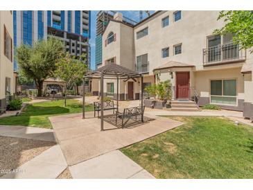 Inviting courtyard with pergola, benches, and lush green grass, perfect for relaxing and enjoying the outdoors at 100 E Fillmore St # 227, Phoenix, AZ 85004