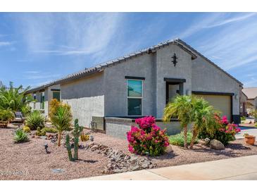 Charming home featuring desert landscaping with vibrant bougainvillea bushes and a decorative dry creek bed at 21150 N Evergreen Dr, Maricopa, AZ 85138