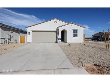 Charming single-story home featuring a desert-style gravel yard, a two-car garage and a welcoming arched entryway at 22085 N Rummler Ln, Maricopa, AZ 85138