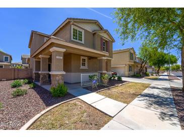 Two-story home featuring a covered porch with stone accents and manicured landscaping at 2337 E Fraktur Rd, Phoenix, AZ 85040