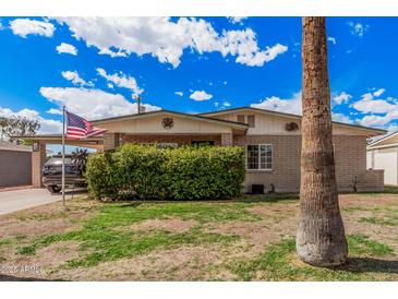 Charming brick home featuring a well-manicured front yard and mature landscaping at 3238 W Altadena Ave, Phoenix, AZ 85029