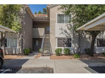 Inviting condo complex with well-maintained landscaping, covered parking, and staircase access to upper units at 3830 E Lakewood Pkwy # 1051, Phoenix, AZ 85048