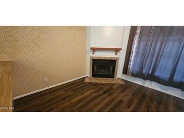 Inviting living room with classic fireplace and modern hardwood floors at 4601 N 102Nd Ave # 2202, Phoenix, AZ 85037