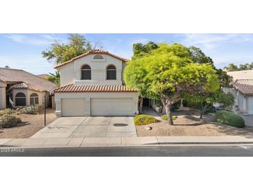 Charming two-story home with a well-manicured lawn and a two-car garage at 630 W Navarro Ave, Mesa, AZ 85210