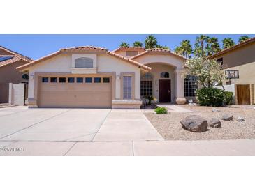 Charming single-story home featuring a terracotta tile roof, stucco exterior, and well-maintained desert landscaping at 10952 S Desert Lake Dr, Goodyear, AZ 85338
