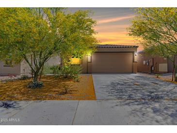 Inviting single-Gathering home with a 2-car garage, complemented by desert landscaping and a picturesque sunset backdrop at 12565 W Palmaire Ave, Glendale, AZ 85307