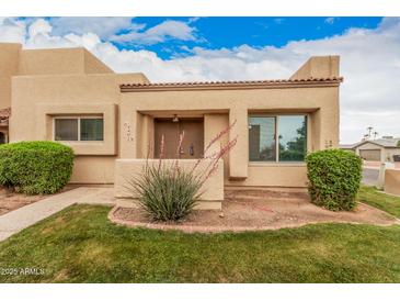 Welcoming desert home with an inviting front entrance and mature shrubbery enhancing its curb appeal at 14402 N 58Th Dr, Glendale, AZ 85306