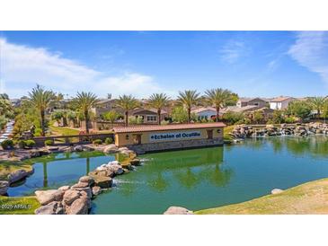 Scenic community pond with lush landscaping, waterfall feature, and a beautiful view of the surrounding neighborhood at 4077 S Sabrina Dr # 48, Chandler, AZ 85248