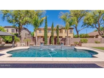 Beautiful backyard pool with fountains and lush landscaping at 614 E Benrich Dr, Gilbert, AZ 85295