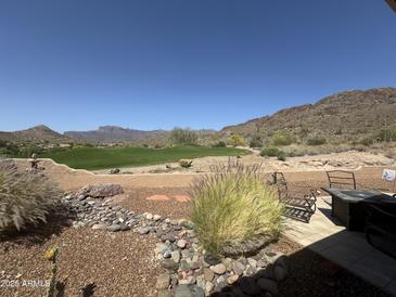Inviting backyard featuring desert landscaping, views of the golf course and surrounding mountains, and a tiled patio area at 9062 E Sonoran Way, Gold Canyon, AZ 85118